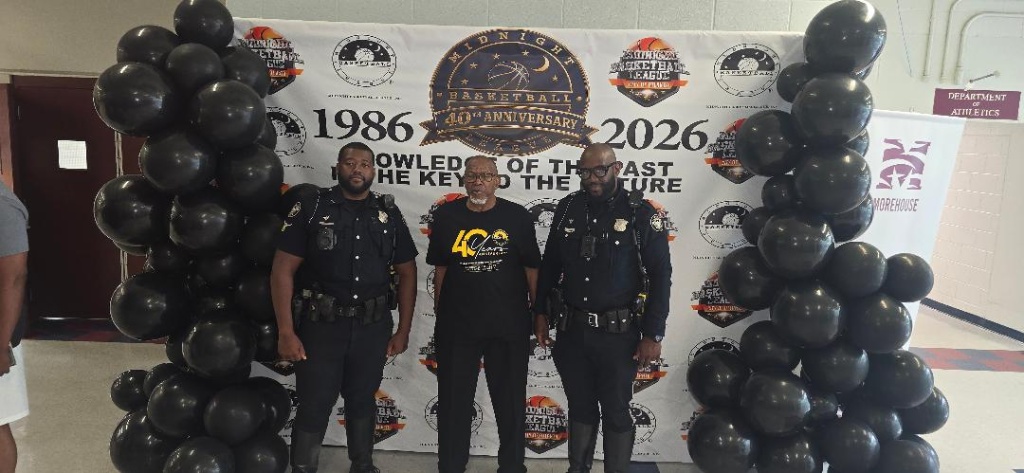 AMB leader poses with two Atlanta Police Department officers in front of the 40th Anniversary step-and-repeat